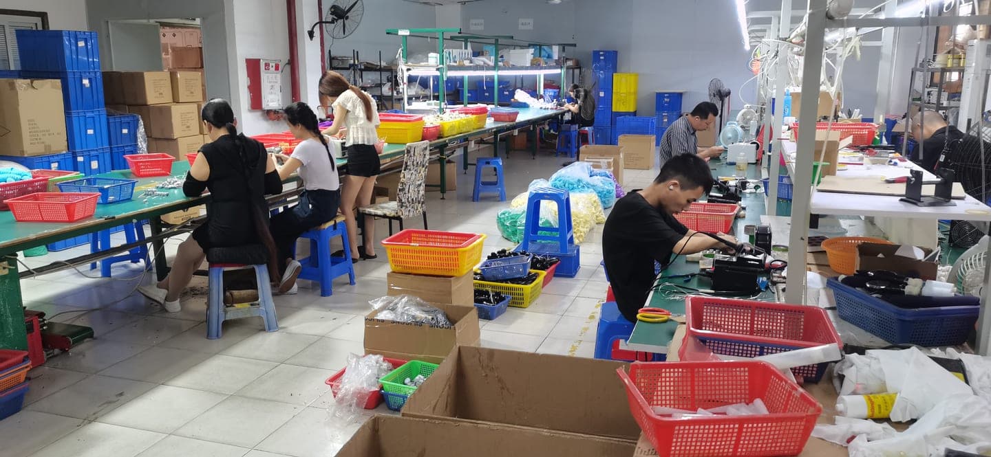 VOVOHO production floor — workers at assembly benches with coloured component bins